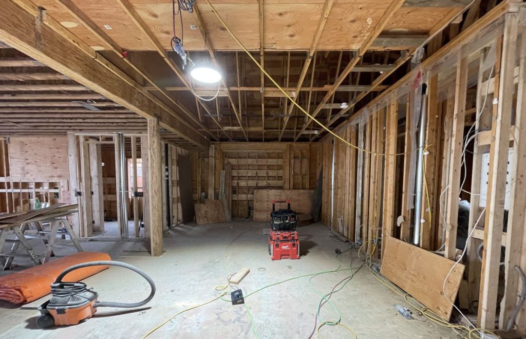 Renovation in progress revealing wiring behind an opened wall in an older home.